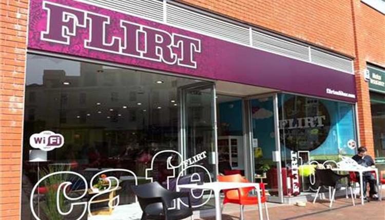 Exterior photo of Flirt Cafe with customers sat in the outdoor seating area